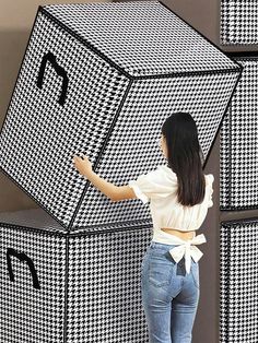 a woman standing in front of some black and white boxes