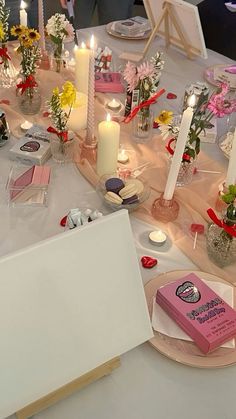 a table is set up with candles, flowers and cards for someone's special occasion