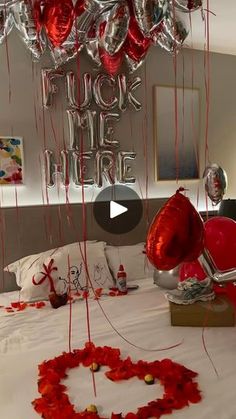 a bedroom decorated for valentine's day with heart balloons