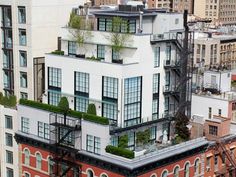 an apartment building with many windows and plants on the roof, in new york city