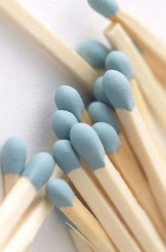 several toothpicks are lined up on top of each other, with blue and white marshmallows sticking out of them