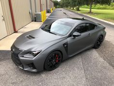 a grey sports car parked in front of a building