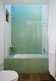 a white toilet sitting next to a bath tub in a bathroom under a skylight