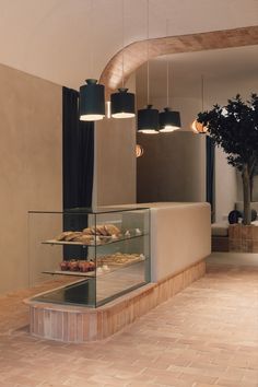 a display case with pastries in it and hanging lights