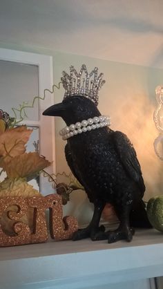 a black bird wearing a crown on top of a mantle