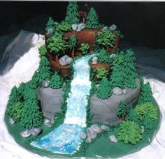 a cake that is shaped to look like a waterfall and trees on the side,