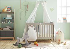 a baby's room with green walls and wooden floors