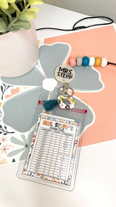 a table with a notepad, keychain and flower pot on top of it