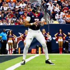 a football player is preparing to throw the ball during a game with an audience in the background