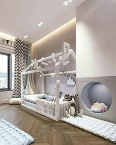 a child's bedroom decorated in white and grey with a bed, rugs, and window