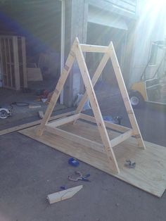 a wooden frame sitting on top of a floor next to construction tools and other items