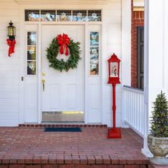 a christmas wreath on the front door of a house with santa's day decorations