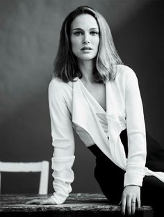 a black and white photo of a woman sitting on a table