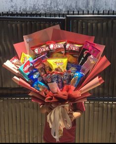 a woman holding a bouquet of candy and snacks