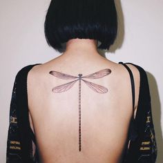 a woman with a dragonfly tattoo on her back