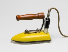 a yellow iron with a wooden handle on a white background, it is used as a lamp