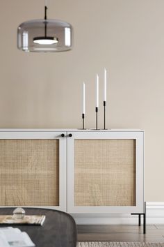 a table with some candles on top of it next to a wall mounted light fixture