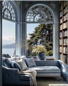 a living room filled with furniture and a large window covered in books next to a book shelf