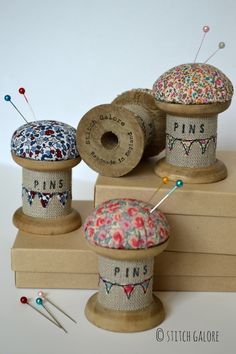 three spools of thread sitting on top of each other next to some sewing needles