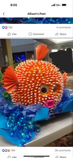 an orange and blue fish made out of pencils sitting on top of a table