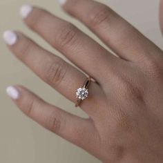 a woman's hand with a diamond ring on it