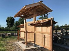 a wooden structure sitting in the middle of a field