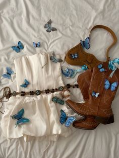 a pair of cowboy boots sitting on top of a bed next to some blue butterflies