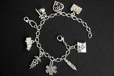 A collection of silver plated medical and EMT themed charms have been dispersed around a shimmering silver plated bracelet chain in this handmade charm bracelet. This emergency medical technician charm bracelet is then completed with a lobster clasp and a 1/2 inch of chain at the end for adjustable sizing. Charms in this bracelet include a caduceus charm, ambulance charm, syringe charm, hospital charm, medic bag charm, syringe with bottle charm, EMT with star charm, EMT heart charm, and stethosc Silver Hypoallergenic Charms, Silver Symbolic Charm Bracelet Hypoallergenic, Symbolic Silver Hypoallergenic Charm Bracelet, Silver Hypoallergenic Charm Bracelet, Hypoallergenic Silver Charm Bracelet, Hypoallergenic Silver Round Charm Bracelet, Medic Bag, Handmade Charm Bracelets, Emergency Medical Technician