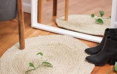 a pair of black boots sitting on top of a wooden floor next to a mirror