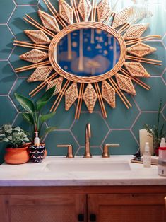 a bathroom sink with a mirror above it and plants on the counter next to it