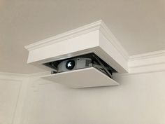 a camera mounted to the side of a wall in a room with white walls and ceiling