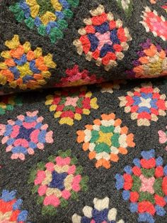 a multicolored crocheted blanket with flowers on it