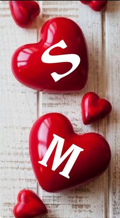 two heart shaped candys with the letter s and h on them sitting next to each other