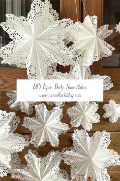 white paper snowflakes hanging from a wooden door with the words diy paper doily snowflakes