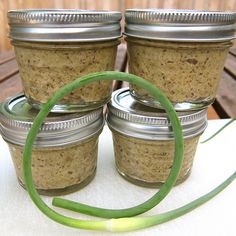 four jars filled with food sitting on top of a table