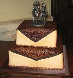 a three tiered cake with two men on top