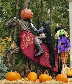 a statue of a man riding on the back of a horse next to pumpkins