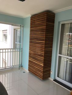 a room with blue walls and white tile flooring next to a tall wooden structure