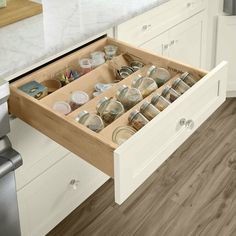 an open drawer in the middle of a kitchen