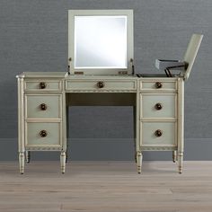 an antique dressing table with mirror and stool