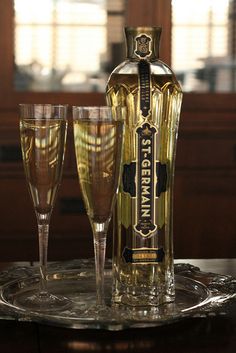 a bottle and two glasses sitting on a table