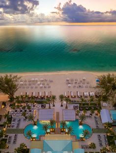 an aerial view of the beach and pool at sunset