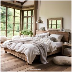 a bed with white sheets and pillows in a bedroom next to large windows that look out onto the woods