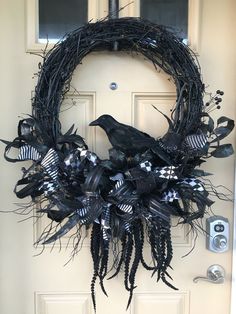 a wreath with black and white decorations is hanging on the front door to give it a spooky look