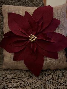 a red flower is sitting on top of a pillow