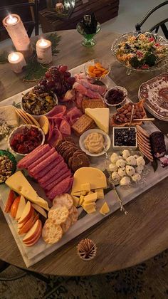 a wooden table topped with lots of different types of cheeses and meats on it