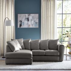 a living room with blue walls and white curtains