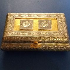 an ornately decorated gold box sitting on a blue surface