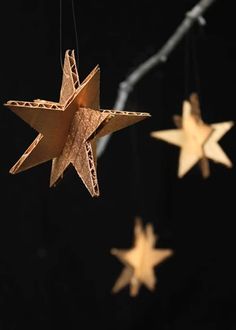 three wooden stars hanging from strings in the dark