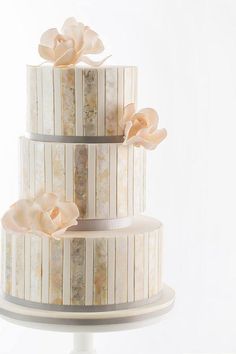 a three tiered cake with flowers on top